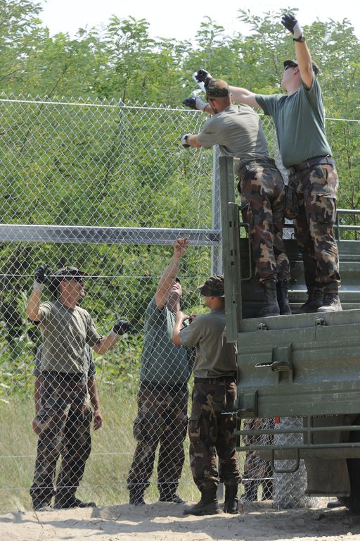 Mórahalom, 2015. július 17. Katonák dróthálót feszítenek a kerítésoszlopokra az ideiglenes biztonsági határzár kiépítésén a magyar-szerb határon, Mórahalom térségében 2015. július 17-én. MTI Fotó: Kelemen Zoltán Gergely
