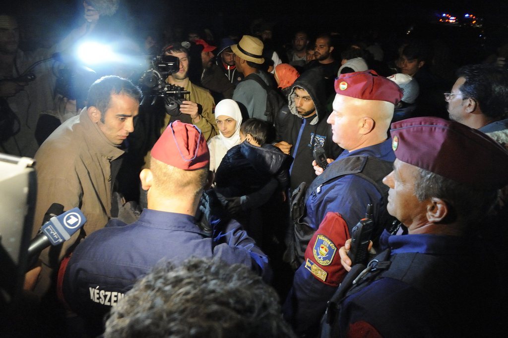 Rendőrök migránsokkal beszélnek az M5-ös autópályán Szeged közelében 2015. szeptember 7-én. Közel ezer migráns kijutott a röszkei gyűjtőpontról, miután áttörtek a rendőri élőkordonon. Az emberek egy része elindult Budapest felé az M5-ös autópályán. MTI Fotó: Kelemen Zoltán Gergely