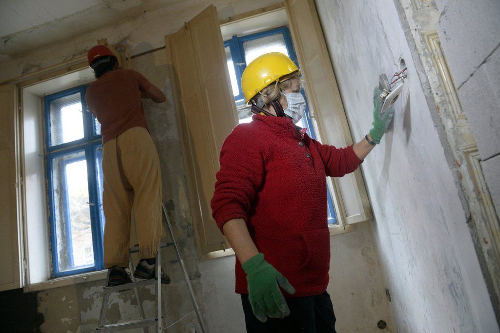 Önkéntesek dolgoznak egy épület felújításán Kispesten. MTI: Kovács Tamás